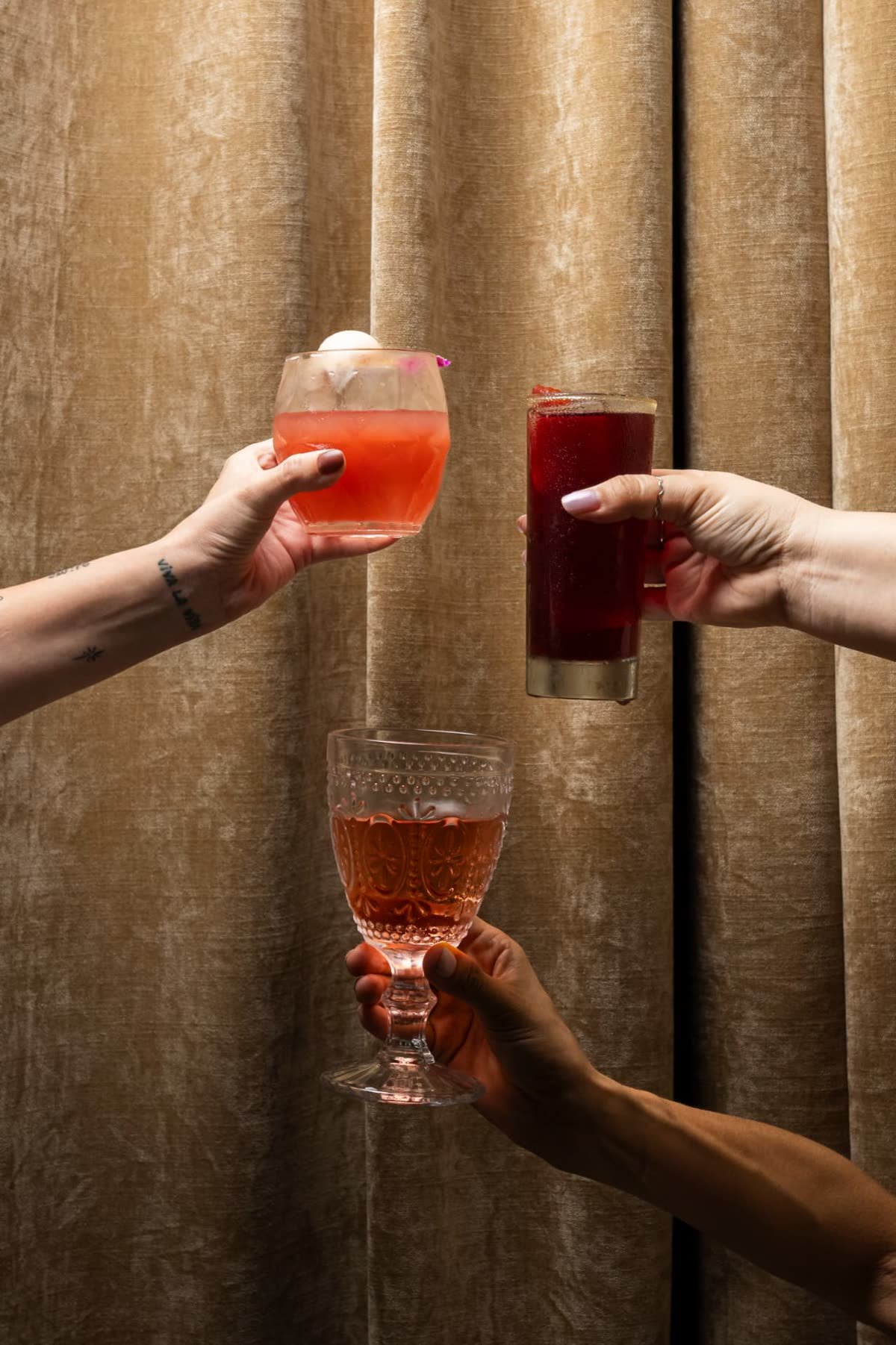 Brindis con cócteles frente a las cortinas de Alura